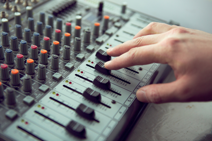 Expert adjusting audio mixing console